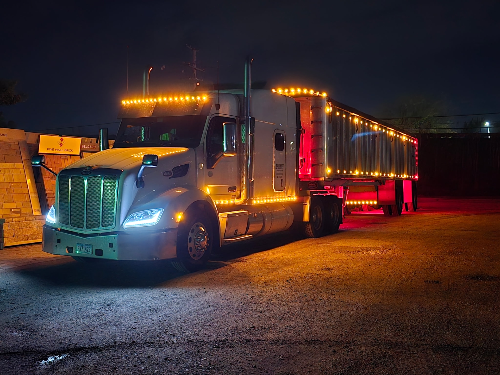 Illuminated semi truck parked at night.